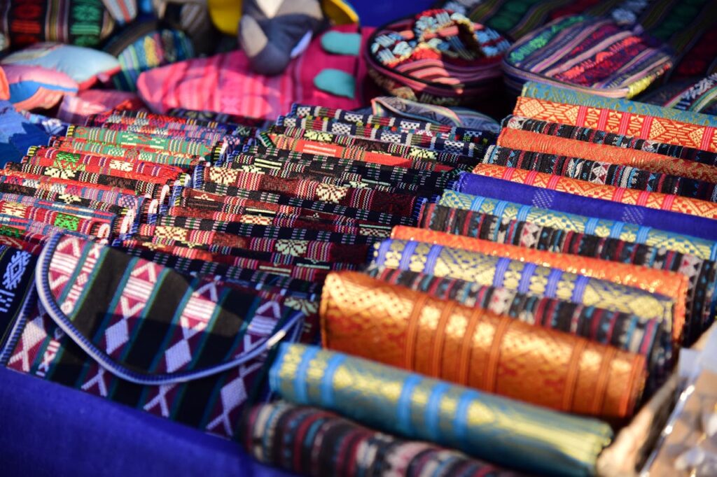 Vibrant handmade textiles on display at an outdoor artisan market showcasing traditional weaving.